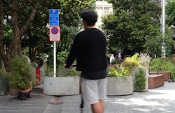 A person rides through a public square on an escooter